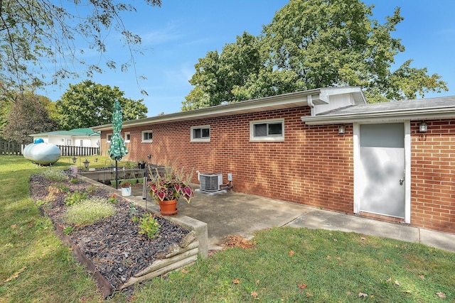 back of house with a lawn, a patio area, and central AC