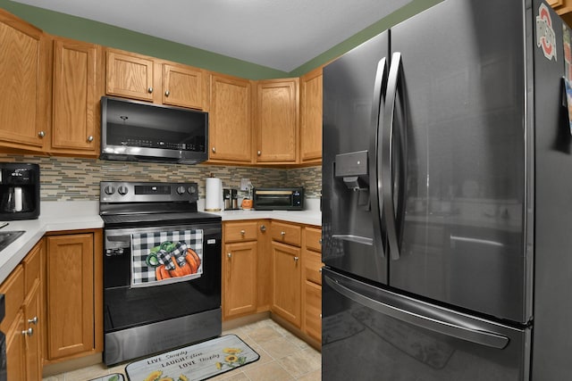 kitchen featuring tasteful backsplash, light tile patterned floors, and appliances with stainless steel finishes