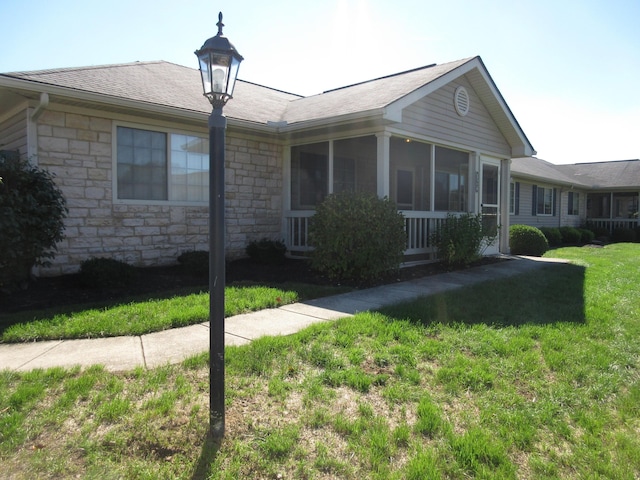 view of front of house with a sunroom and a front lawn