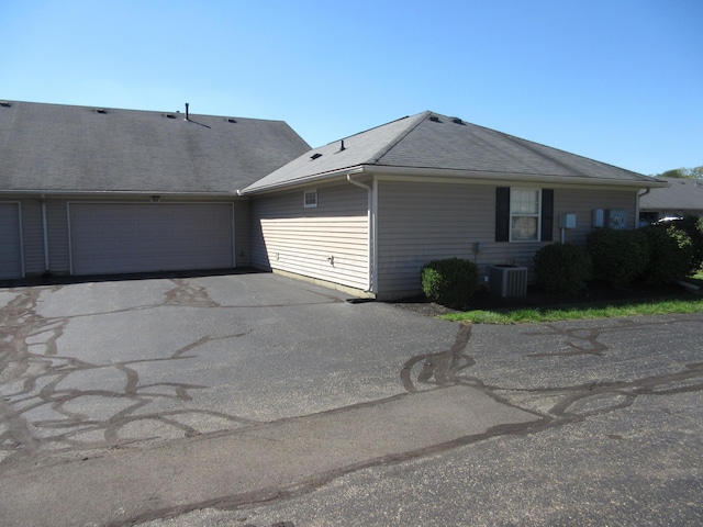 view of home's exterior with central AC unit and a garage