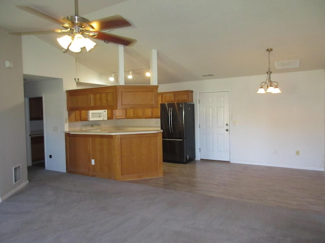 kitchen featuring black refrigerator, carpet flooring, kitchen peninsula, and high vaulted ceiling