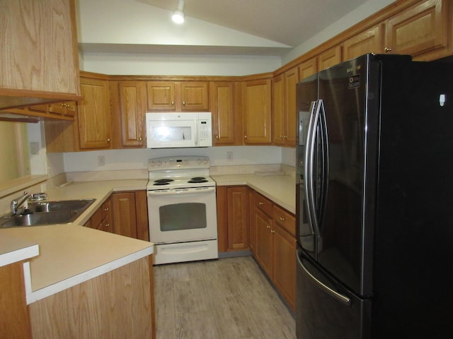 kitchen featuring sink, kitchen peninsula, vaulted ceiling, white appliances, and light wood-type flooring