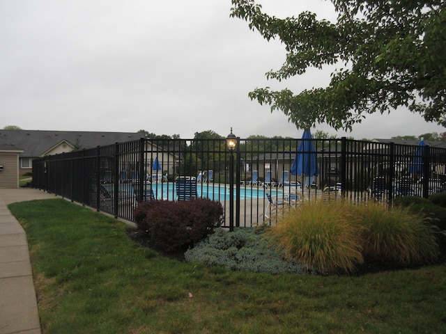 view of swimming pool with a lawn