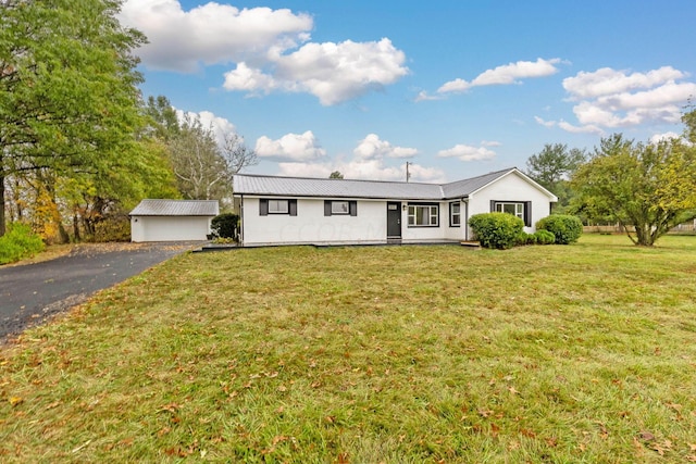 view of front of house with an outdoor structure, a front yard, and a garage