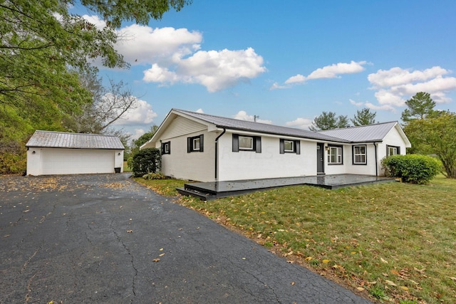 view of front of house featuring a front lawn, an outdoor structure, and a garage