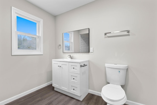 bathroom featuring toilet, vanity, and hardwood / wood-style flooring