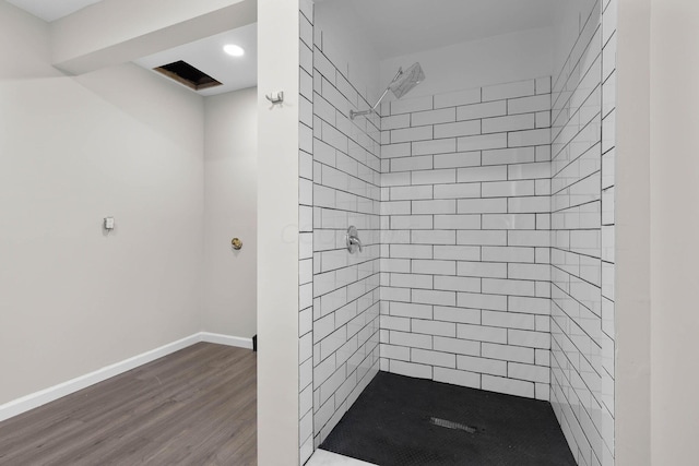 bathroom with hardwood / wood-style flooring and tiled shower