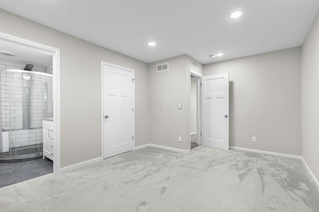 unfurnished bedroom featuring connected bathroom and carpet floors