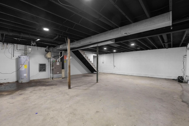 basement featuring heating unit and electric water heater