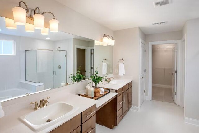 full bath featuring visible vents, a walk in closet, a stall shower, and vanity