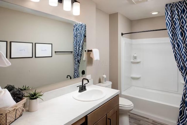 bathroom with wood finished floors, toilet, vanity, and shower / bath combo