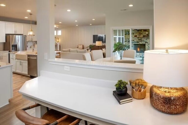 interior space with white cabinetry, appliances with stainless steel finishes, light countertops, and light wood-type flooring