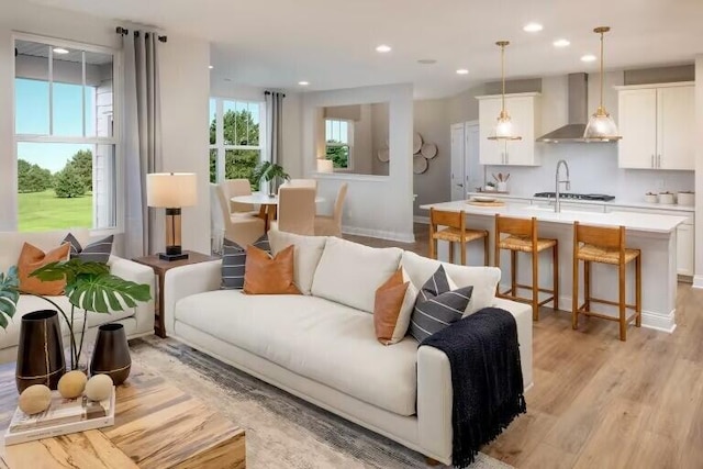 living area with light wood finished floors, recessed lighting, and baseboards