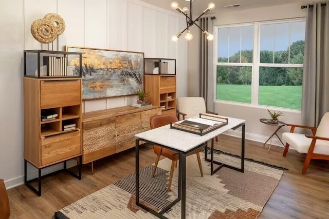 sitting room with visible vents, baseboards, an inviting chandelier, and wood finished floors