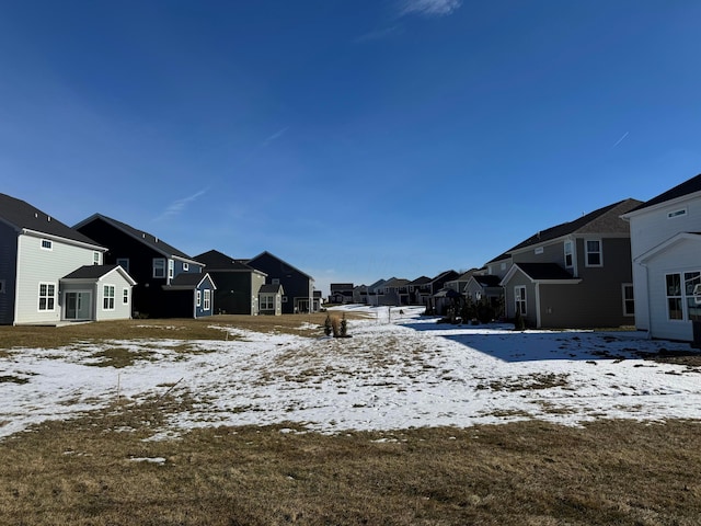 yard covered in snow featuring a residential view