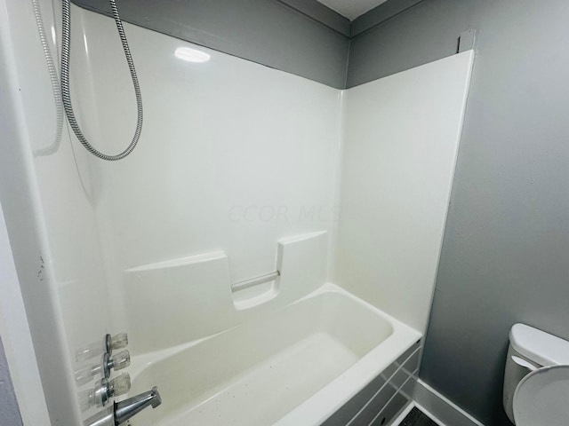 bathroom with washtub / shower combination and toilet