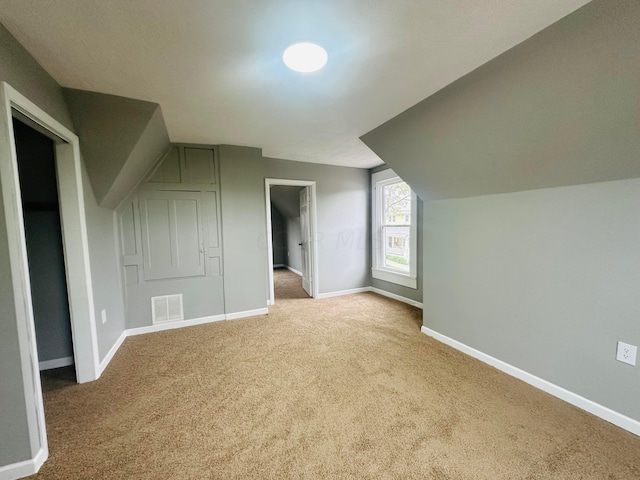 additional living space featuring carpet flooring and lofted ceiling