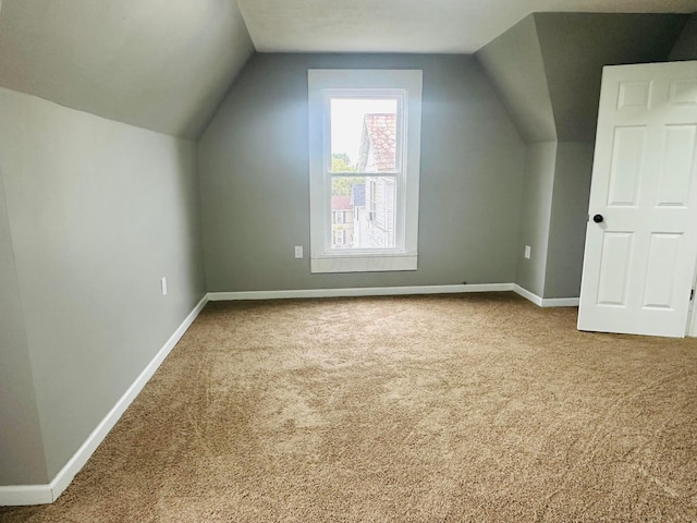 bonus room with carpet flooring and vaulted ceiling