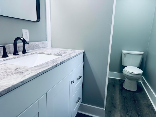 bathroom featuring hardwood / wood-style floors, vanity, and toilet