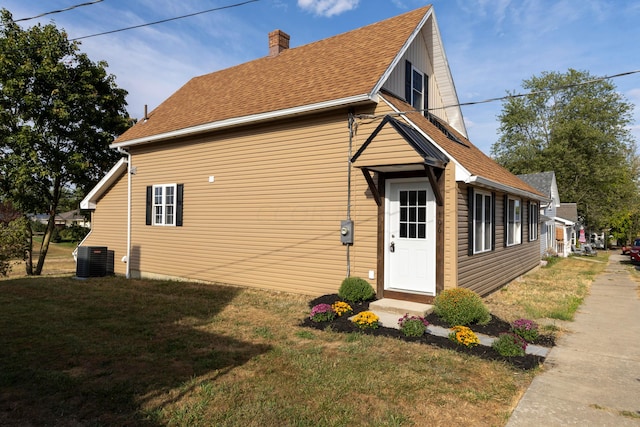 view of property exterior with central AC unit and a yard