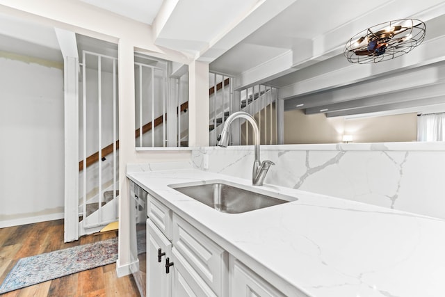 kitchen featuring white cabinetry, sink, light stone counters, dark hardwood / wood-style floors, and decorative backsplash