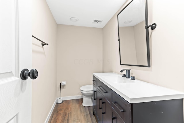 bathroom featuring wood-type flooring, vanity, and toilet