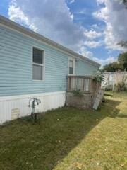 view of side of home featuring a yard and a wooden deck