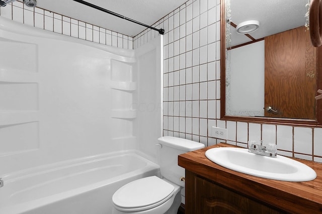 full bathroom with shower / bath combination, vanity, a textured ceiling, tile walls, and toilet