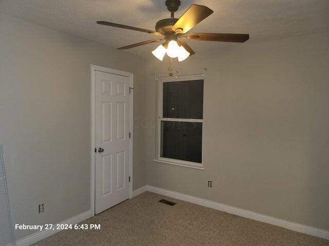 unfurnished room with carpet flooring and ceiling fan