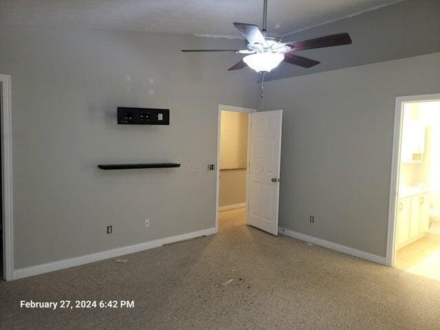 unfurnished bedroom with ensuite bath and ceiling fan