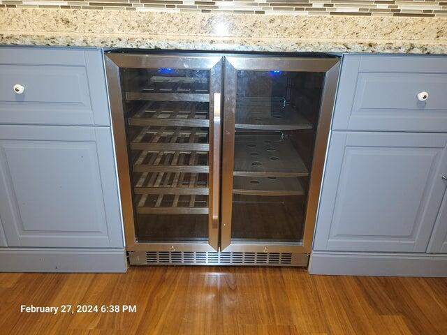 room details featuring wine cooler, white cabinetry, hardwood / wood-style floors, and light stone countertops