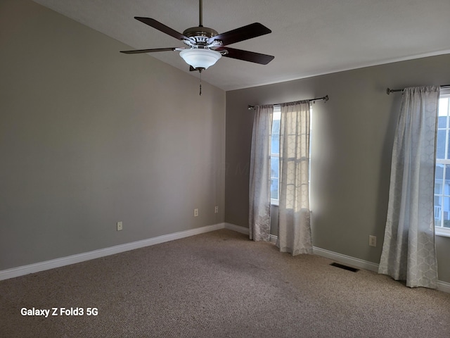 unfurnished room featuring ceiling fan, plenty of natural light, and light colored carpet