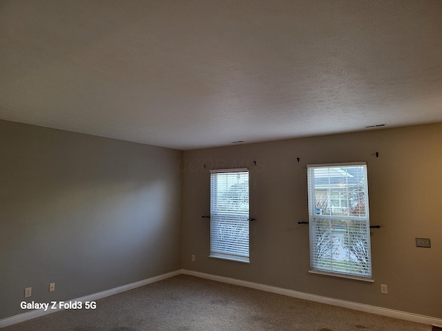 spare room with carpet floors and a textured ceiling