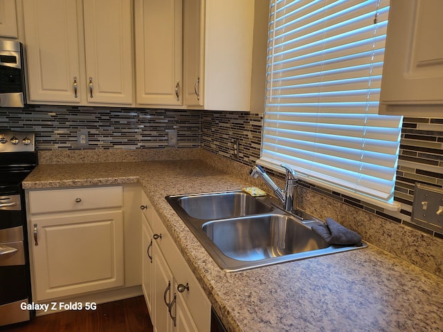 kitchen with white cabinetry, sink, appliances with stainless steel finishes, and tasteful backsplash