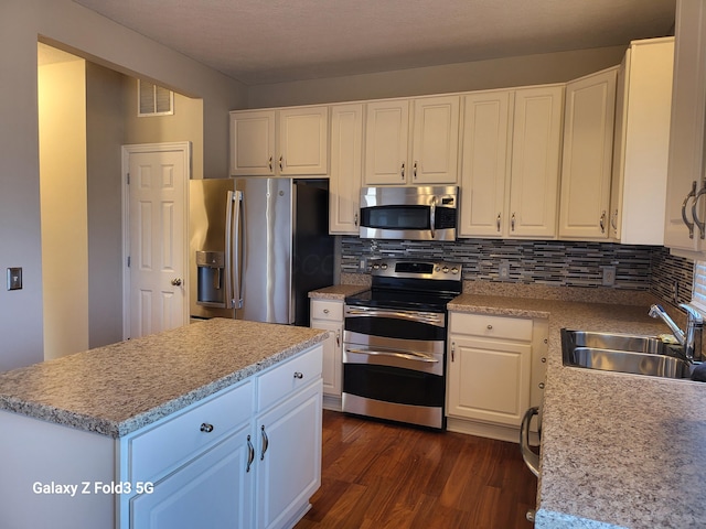 kitchen with sink, white cabinets, dark wood-type flooring, and appliances with stainless steel finishes