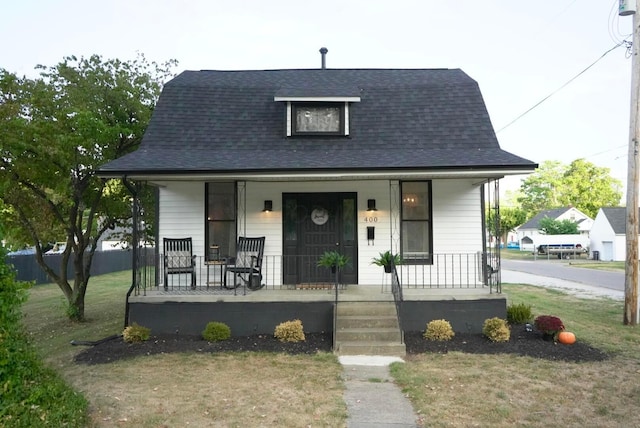 bungalow-style house with covered porch and a front lawn