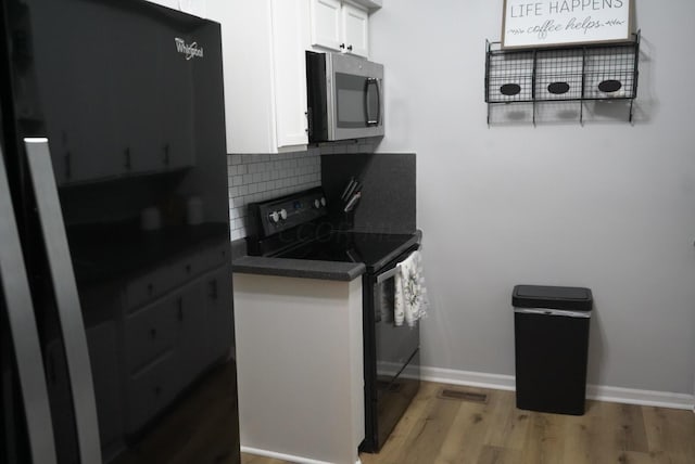 kitchen with white cabinetry, black range with electric stovetop, tasteful backsplash, and light hardwood / wood-style floors