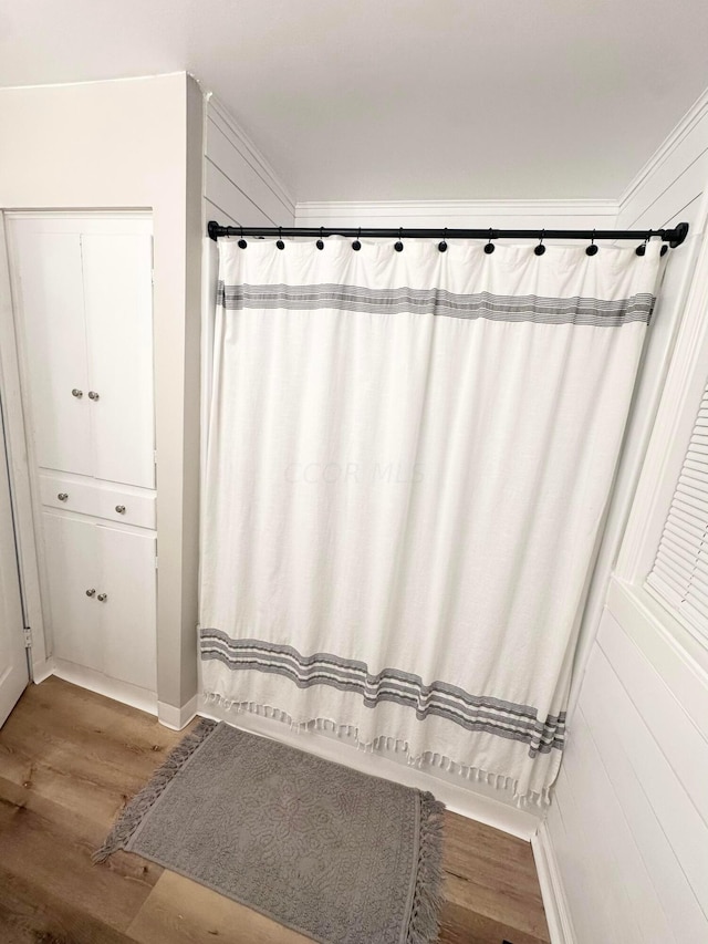 bathroom with hardwood / wood-style floors and crown molding