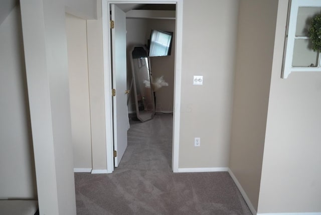 hall with dark colored carpet