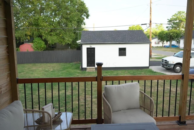 wooden deck with a lawn and a storage unit