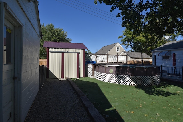 view of yard with a fenced in pool and a shed