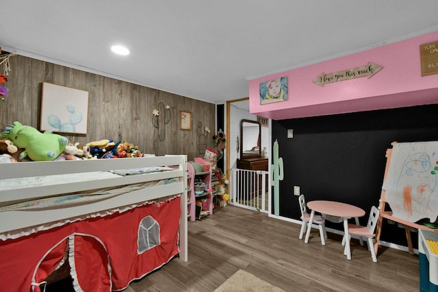 bedroom featuring wooden walls and hardwood / wood-style flooring