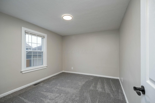 carpeted empty room with a textured ceiling