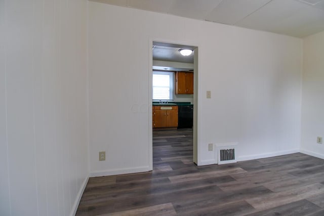 empty room with dark hardwood / wood-style flooring