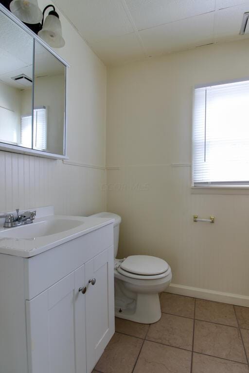 bathroom with tile patterned flooring, vanity, and toilet