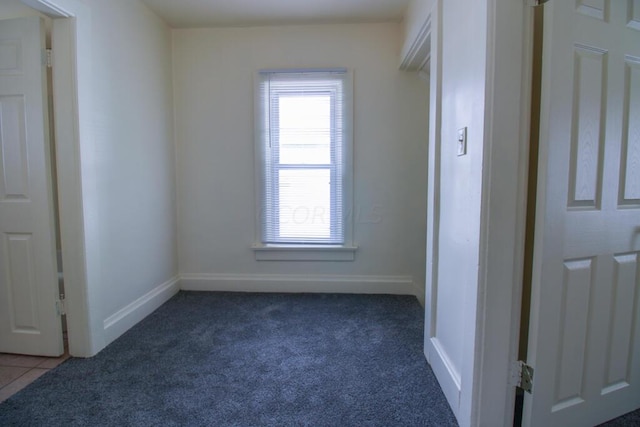 spare room featuring dark colored carpet