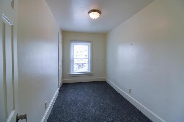 empty room with dark colored carpet