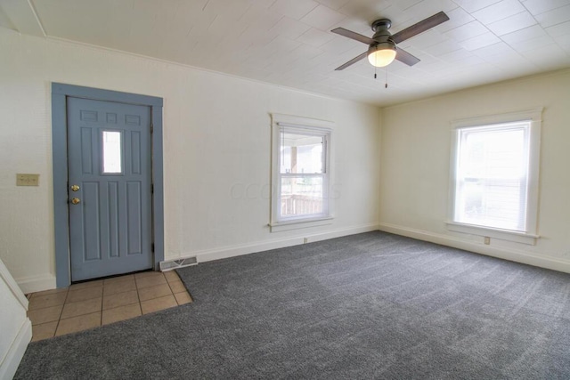 carpeted foyer featuring ceiling fan and plenty of natural light