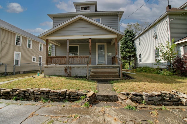 bungalow-style home with covered porch and a front yard