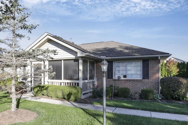 view of front of house with a sunroom and a front lawn